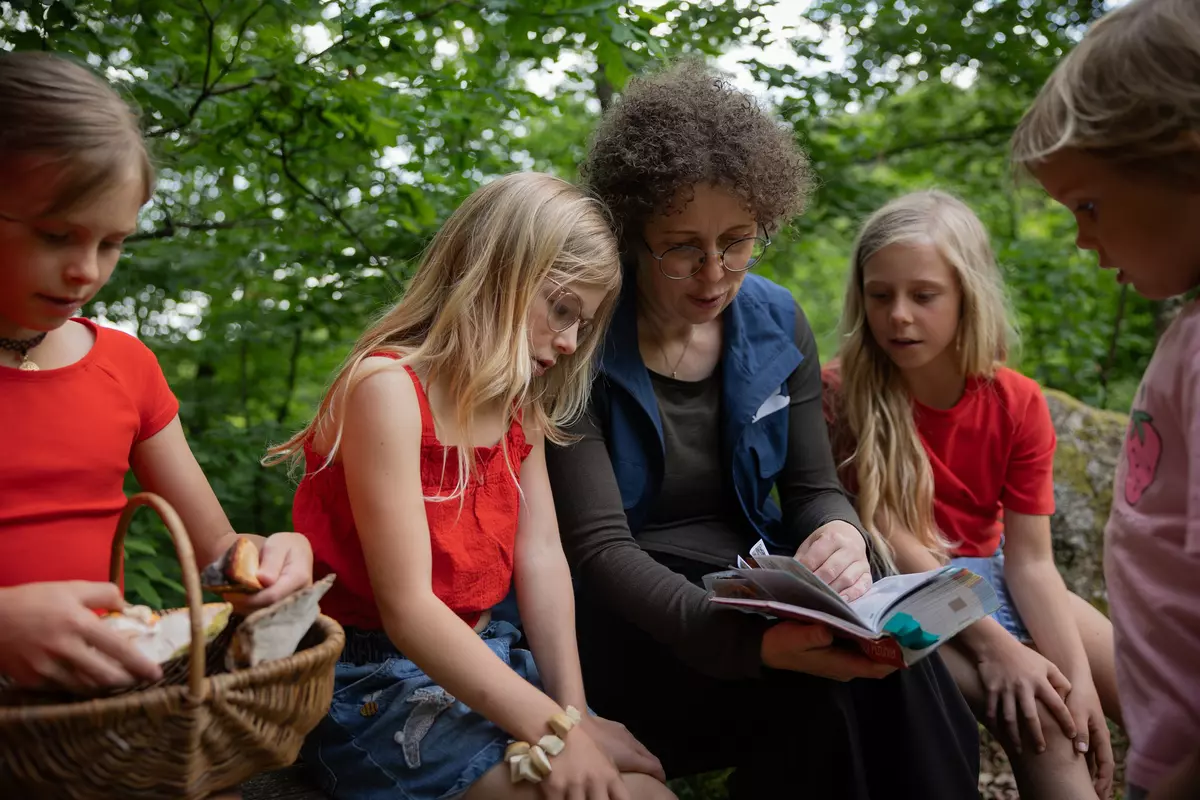 Guide mit Kindergruppe und Buch 