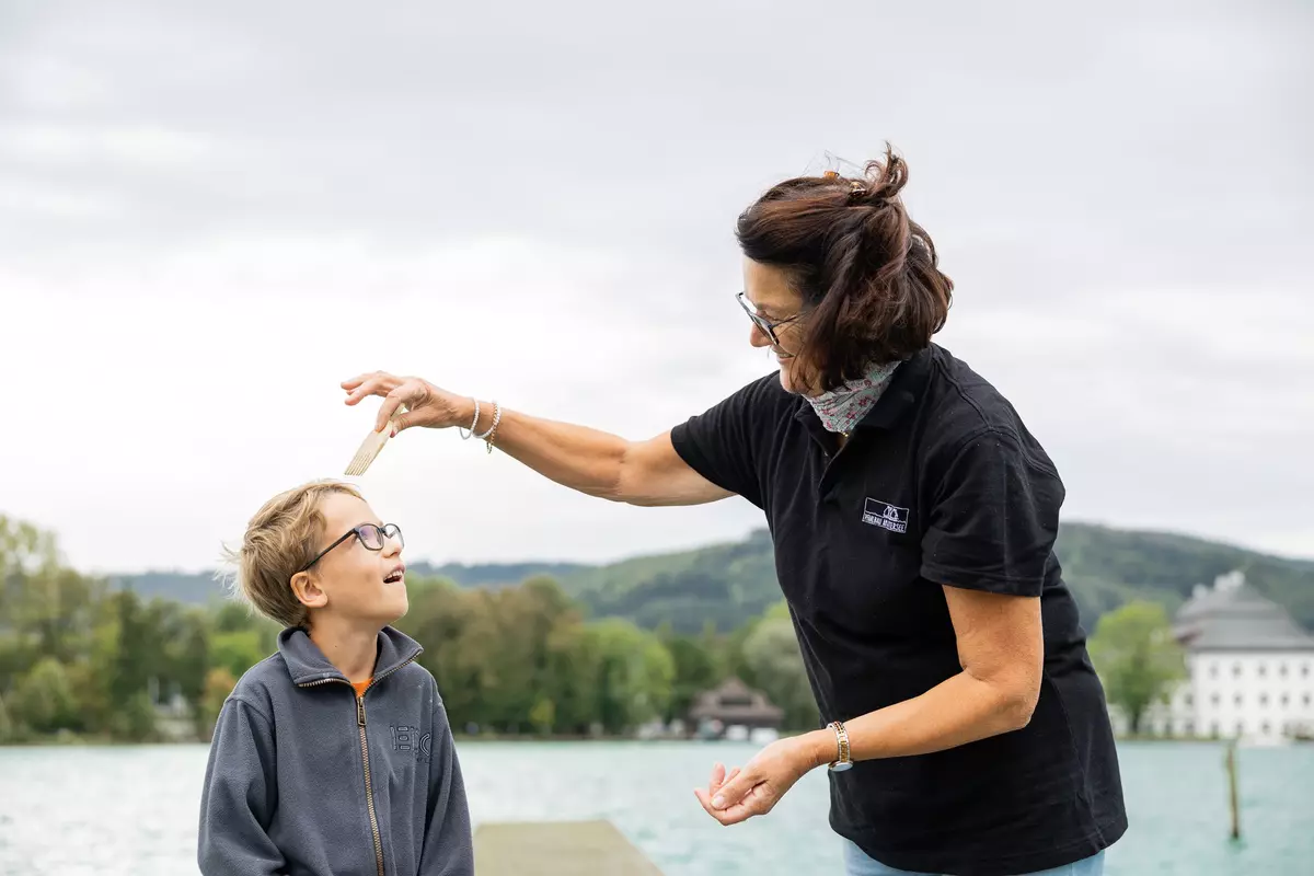 Junge mit Guide auf einem Steg am See