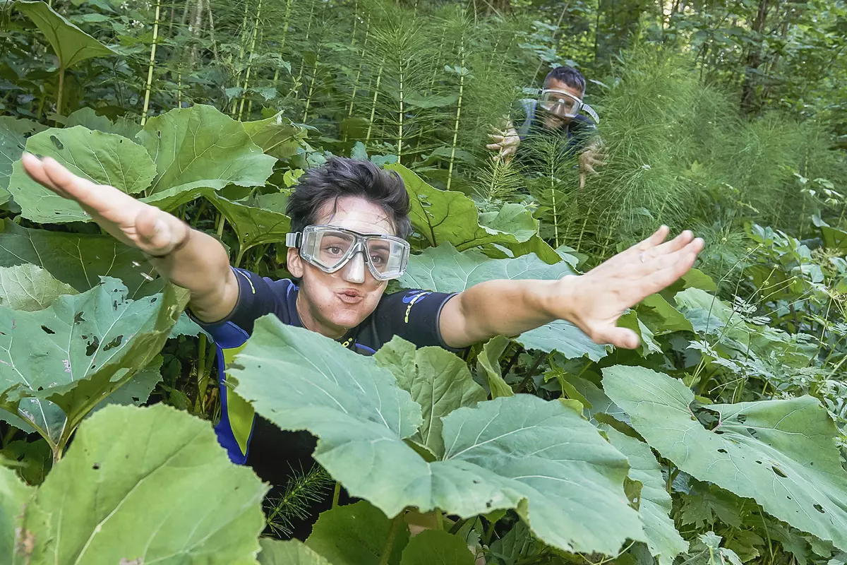 Frau mit Taucherbrille im dichten Wald
