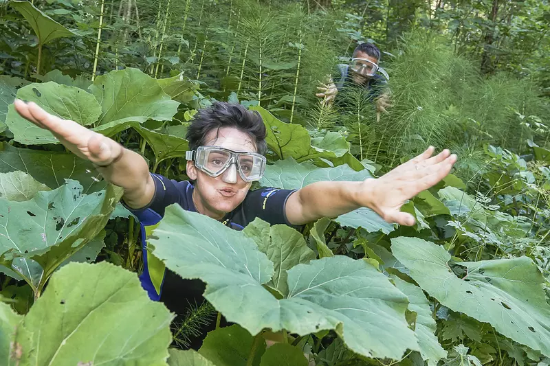 Frau mit Taucherbrille im dichten Wald