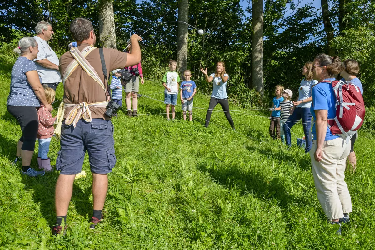 Gruppe steht im Kreis auf einer Wiese