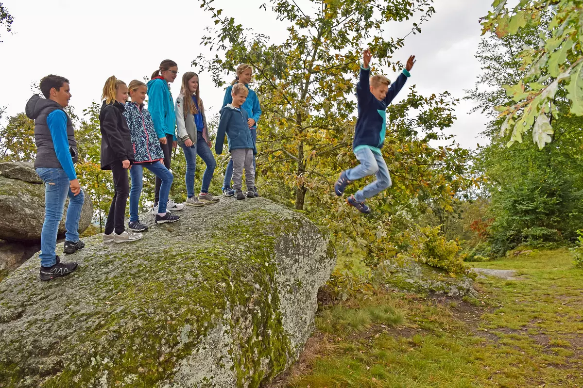 Kinder stehend auf Findling