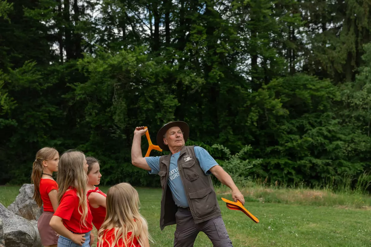Guide mit Kindergruppe und Flugobjekten