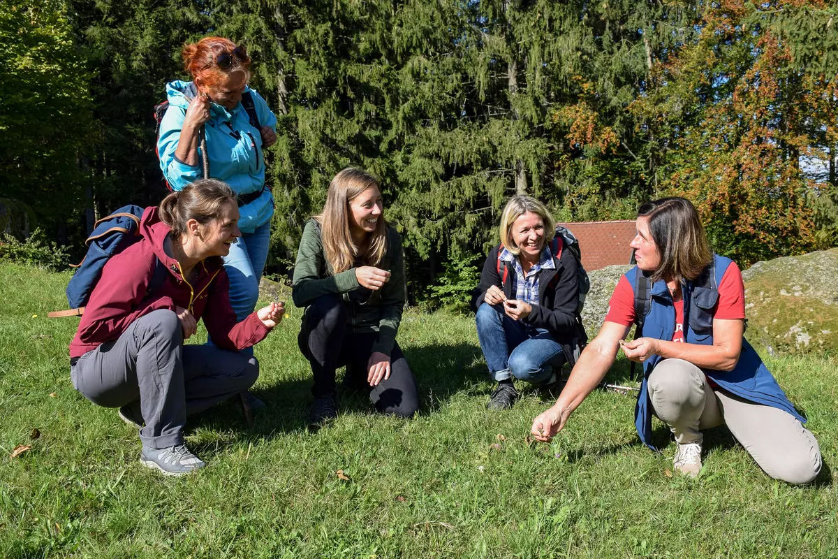 Frauengruppe hockend in der Wiese