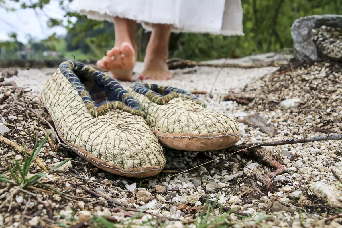Selbstgemachte Schuhe mit Frau im Hintergrund