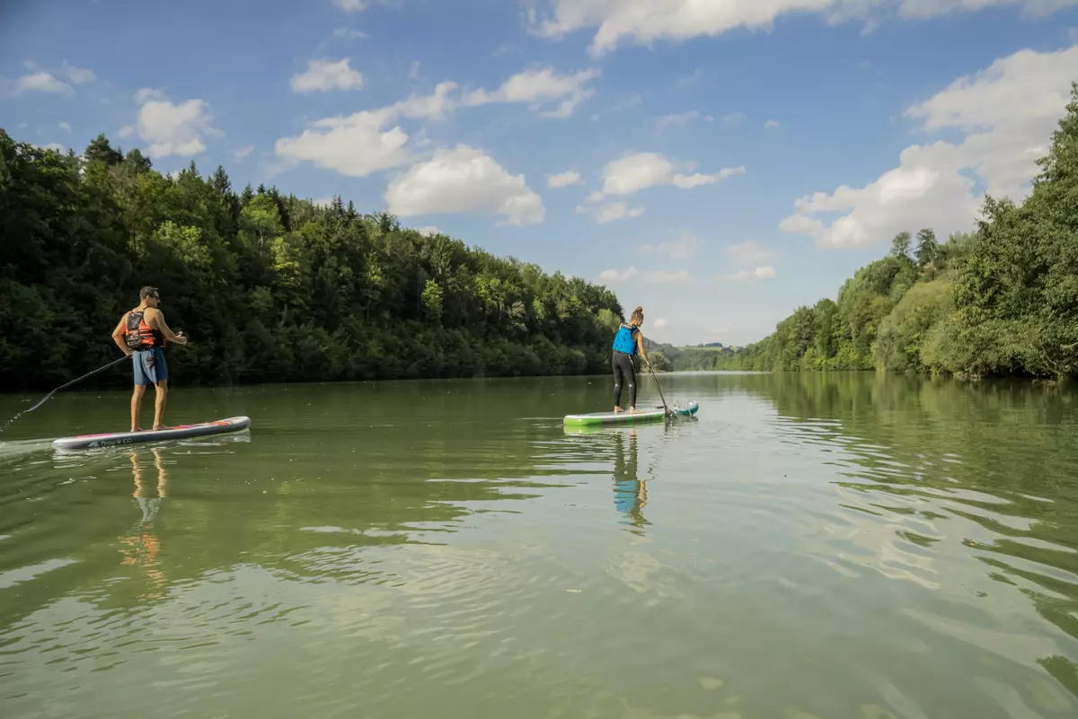 Zwei StandUpPaddler paddeln im Fluss