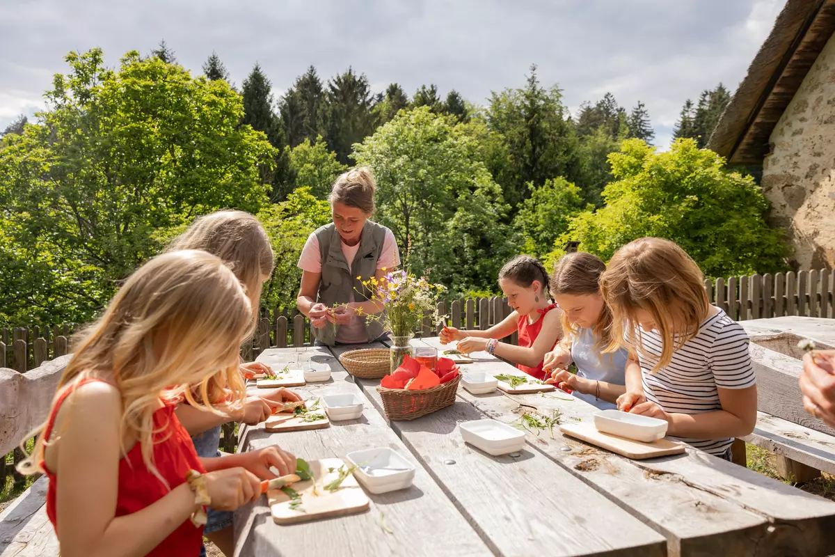 Guide mit Kindergruppe am Tisch 