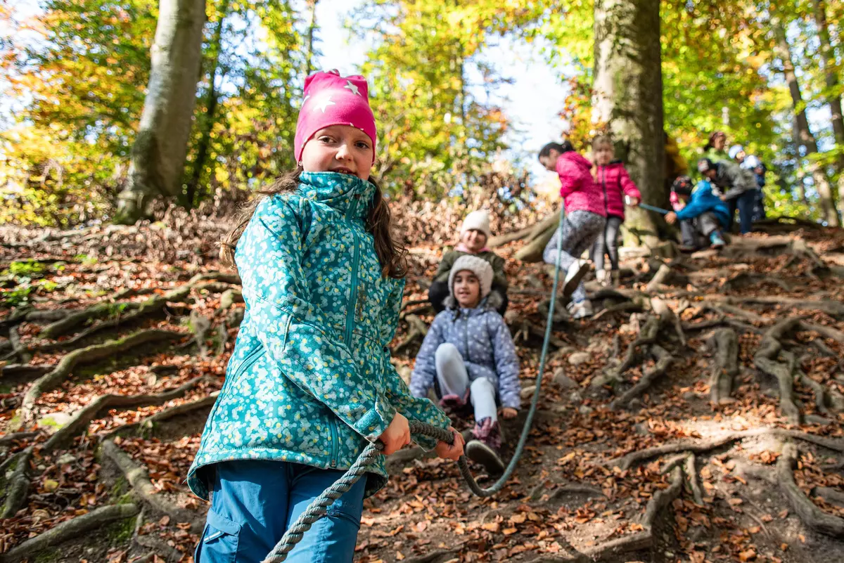 Kinder entlang Seil auf Wurzelgeflecht
