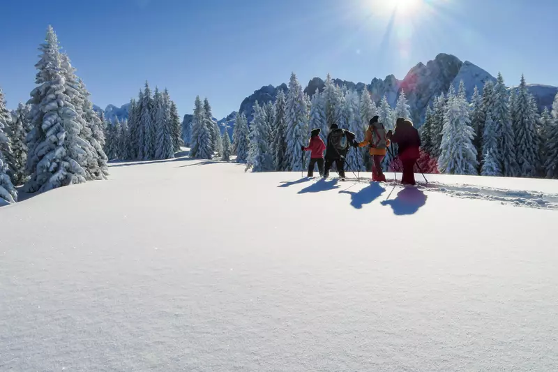 Gruppe mit Schneeschuhen im Sonnenschein