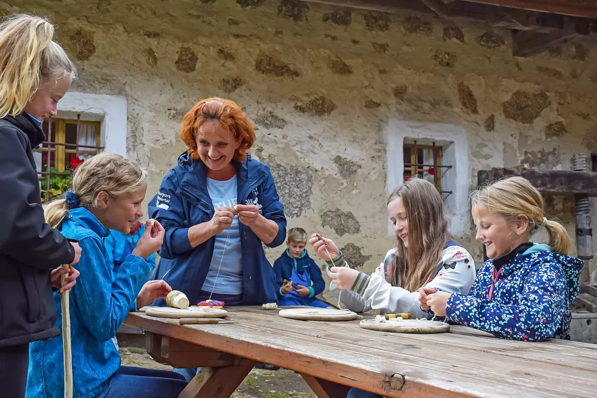 Weiblicher Guide mit Mädchen rund um Holztisch mit Krenwurze