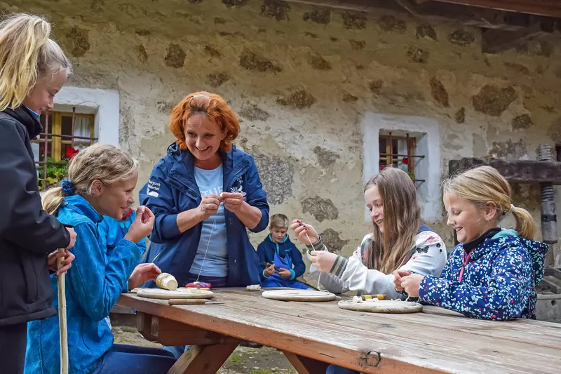 Weiblicher Guide mit Mädchen rund um Holztisch mit Krenwurze