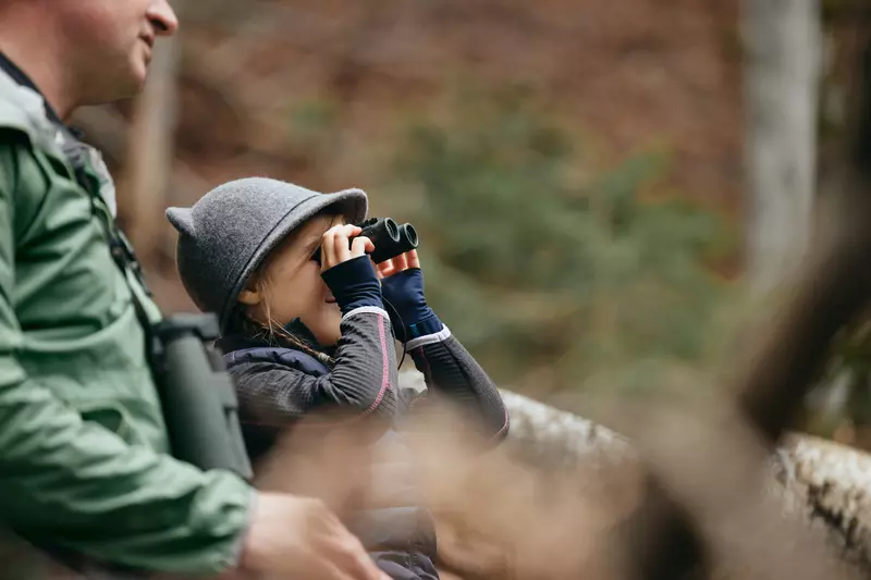 Kind schaut mit Gucker in den Wald