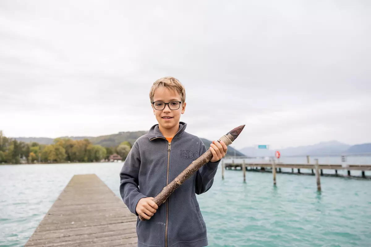 Junge mit selbstgemachten Steinkeil mit Holz