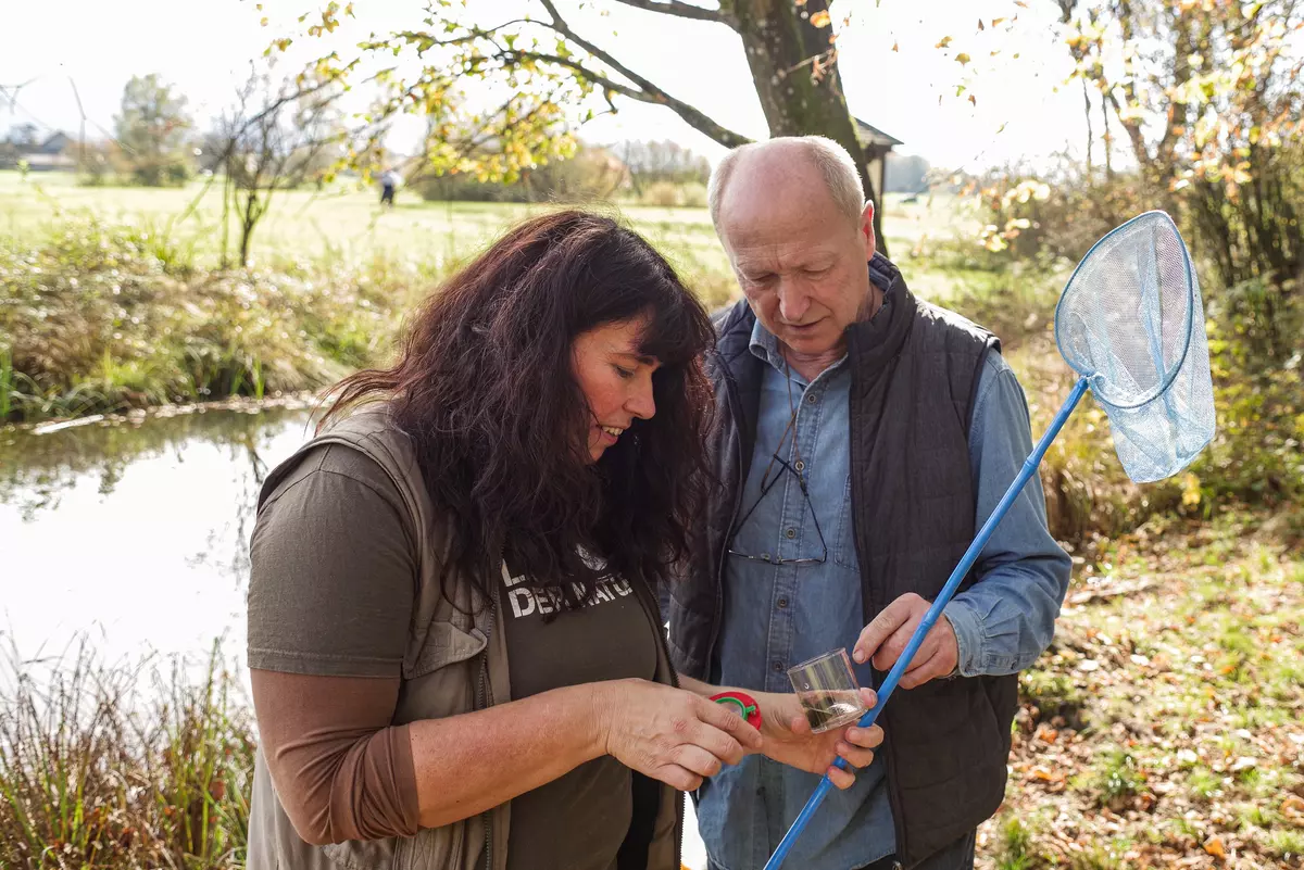 Guide weiblich mit Teilnehmer und Becherlupe