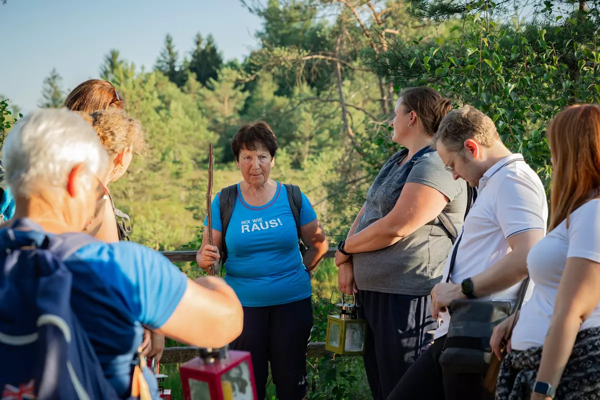 Guide mit Teilnehmenden im Sonnenuntergang in einer Moorlandschaft