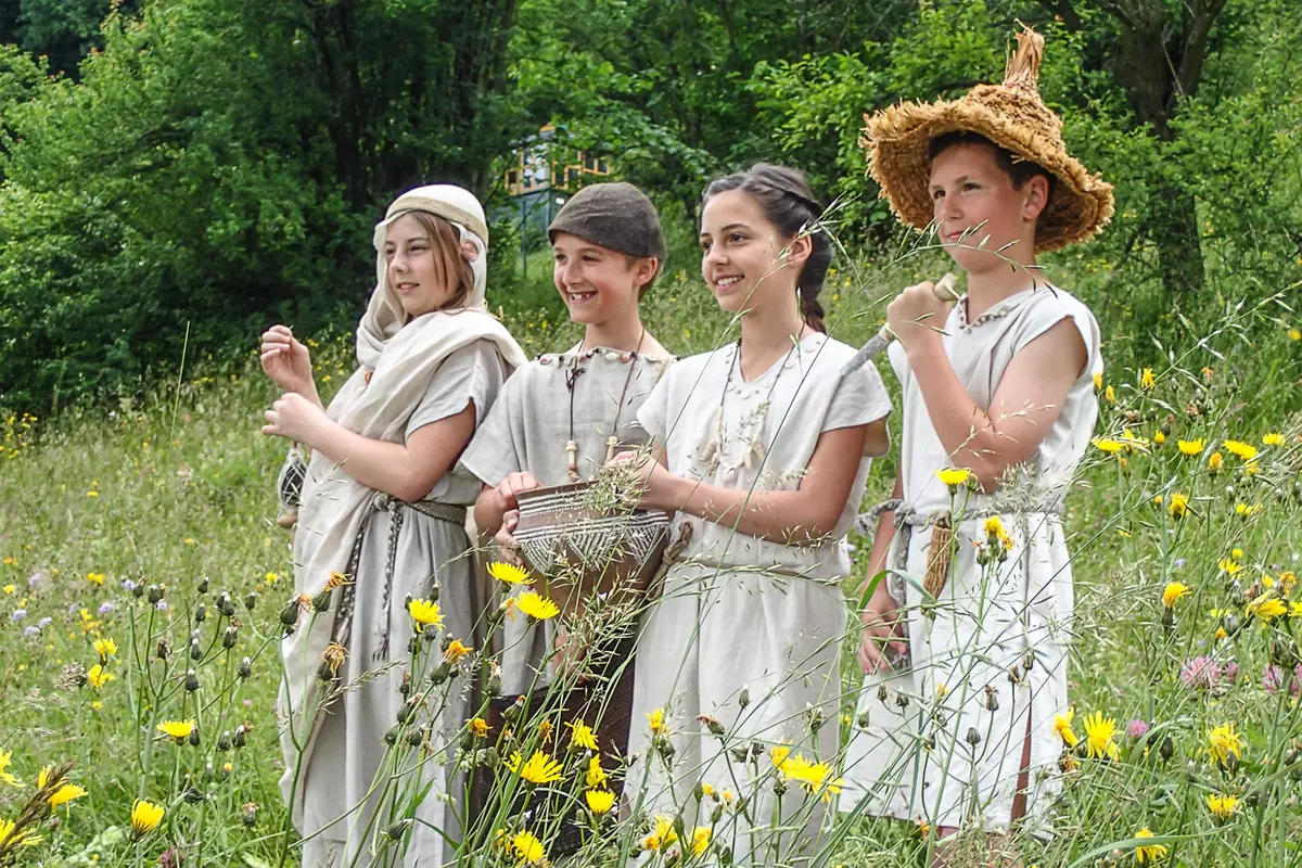 Vier verkleidete Kinder in einer Blumenwiese
