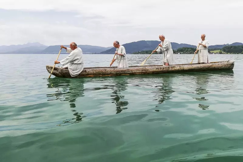 Vier Männer in einem selbstgebauten Kanu am Attersee