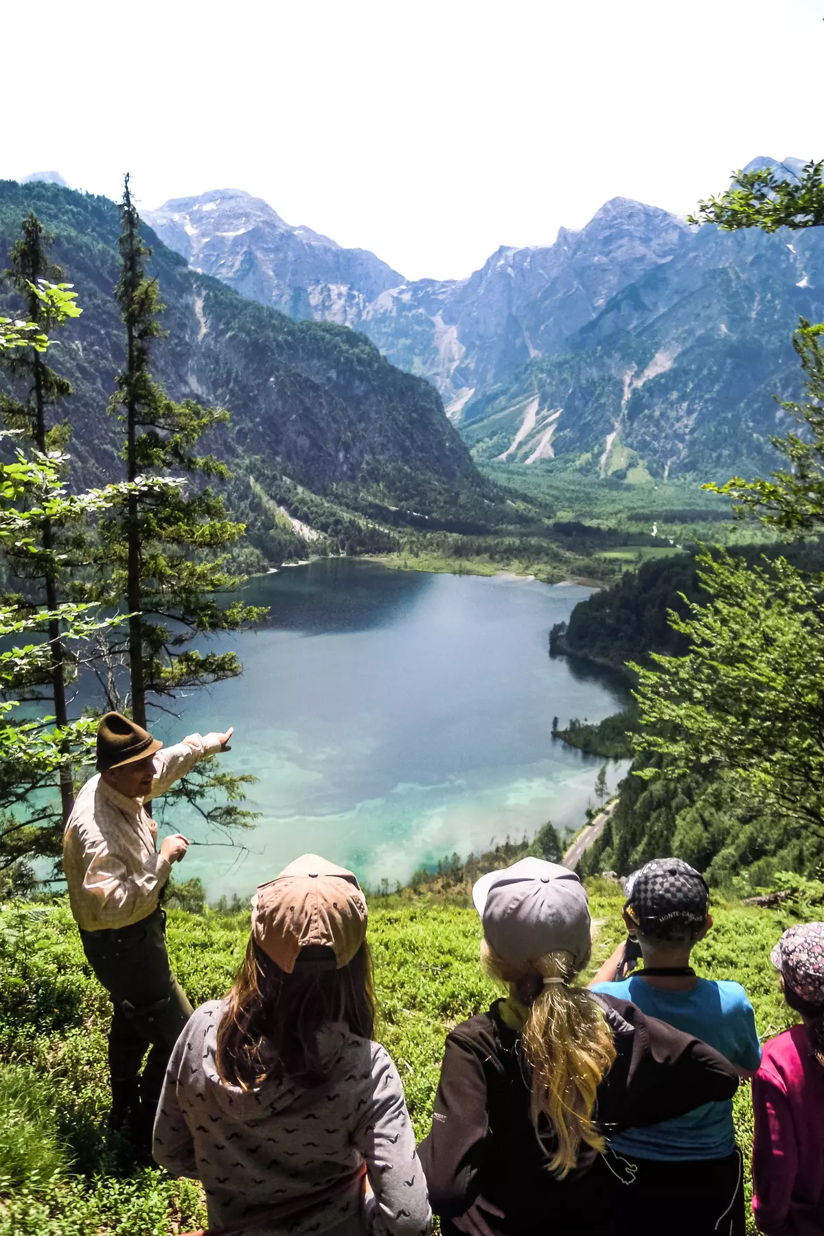 Kindergruppe mit Guide blickt über den Almsee