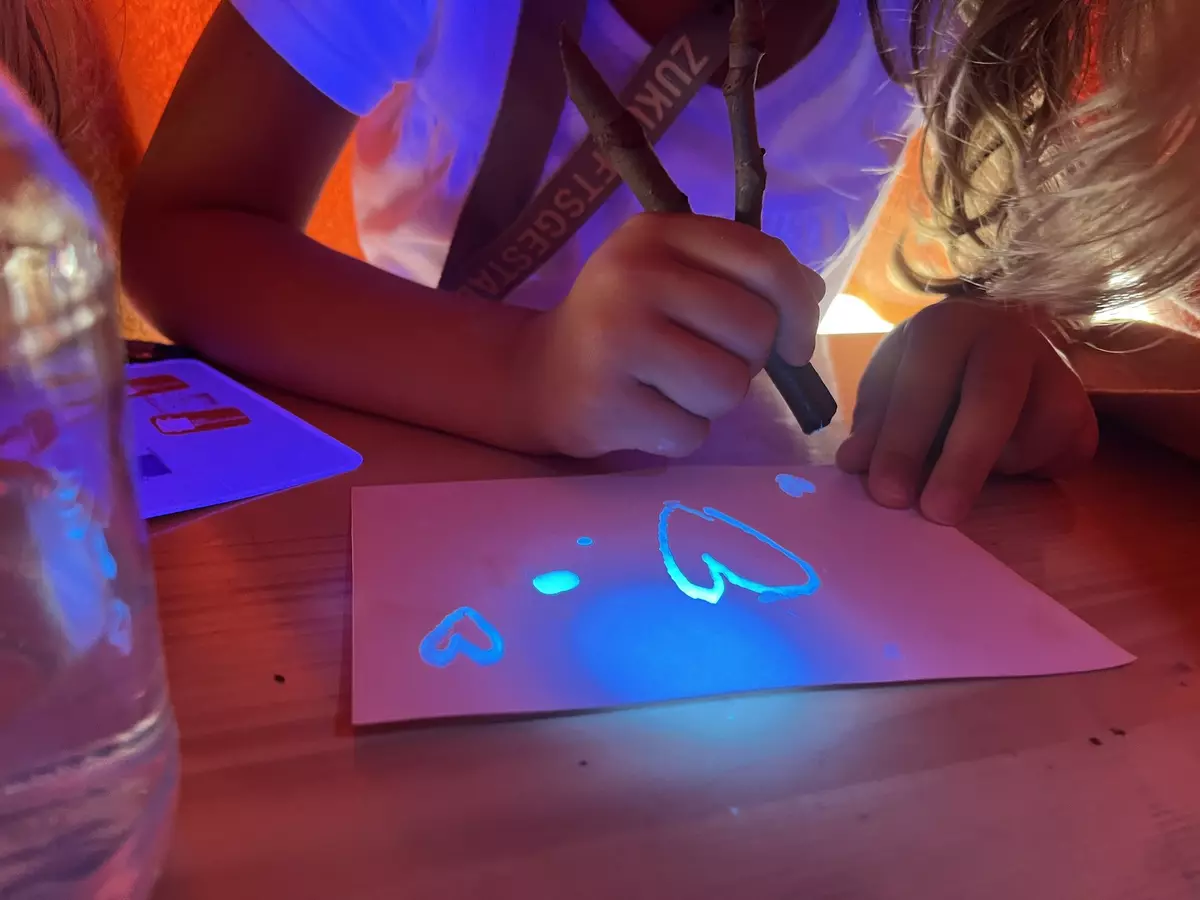 Kind malt mit Farbe, die im Dunkeln leuchtet