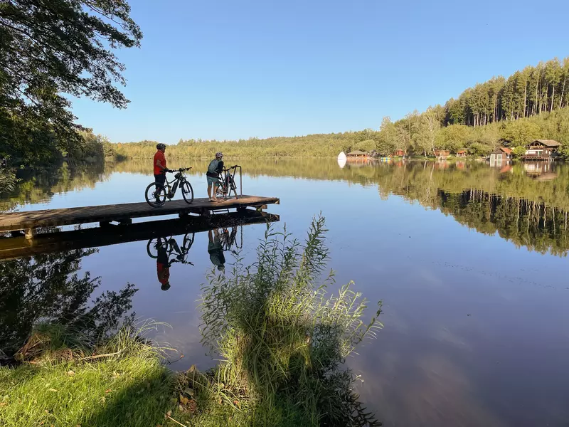 Zwei Personen mit Ebike stehen auf einem Steg am Moorsee