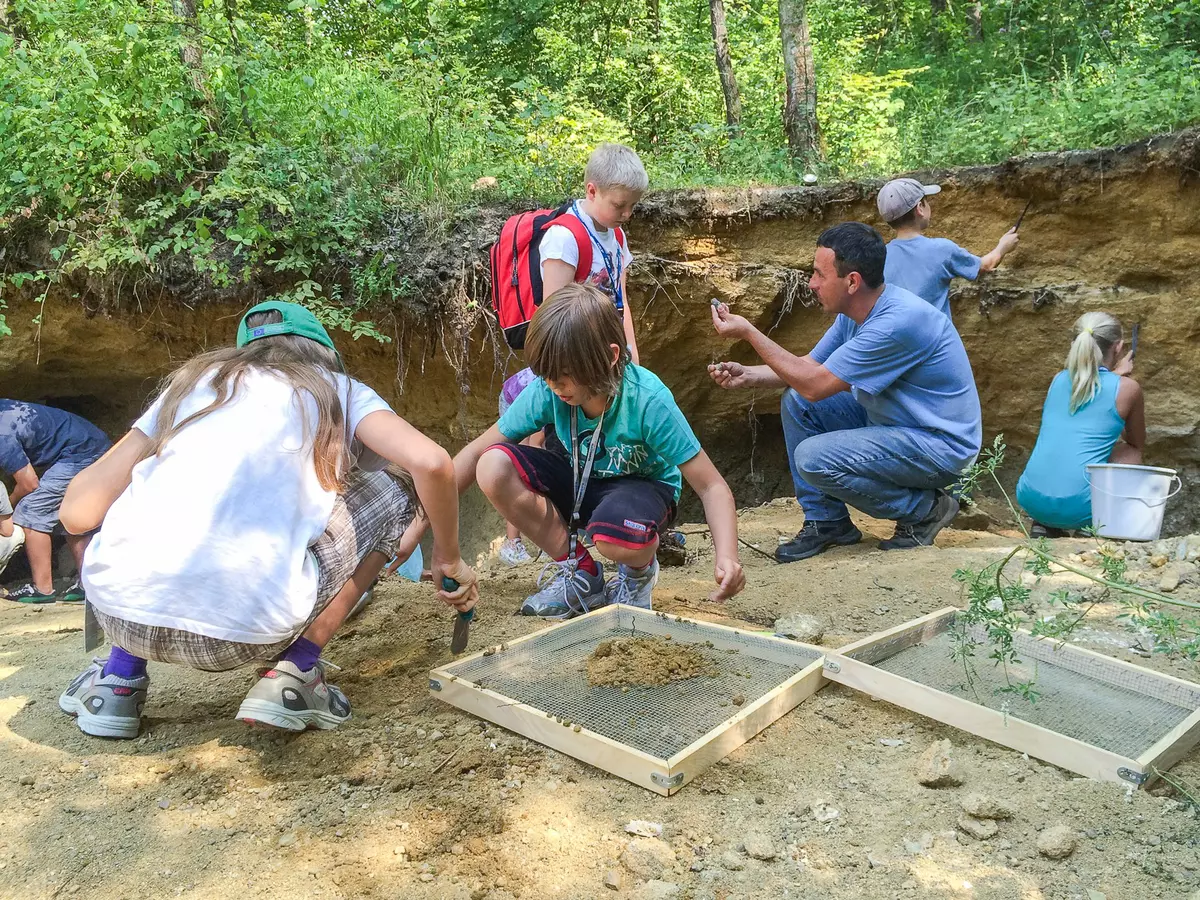 Einige Kinder beim Ausgraben von Fossilien