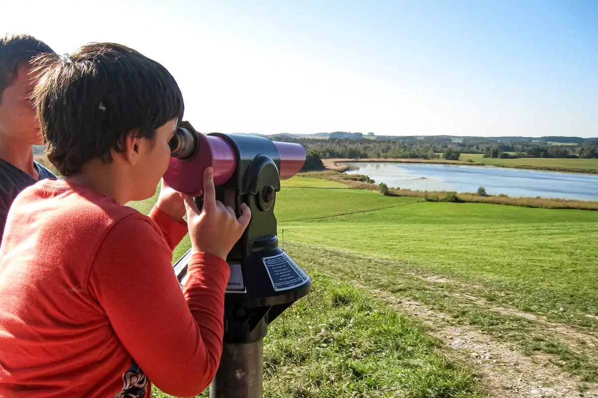 Bursche schaut durch Fernrohr über Landschaft