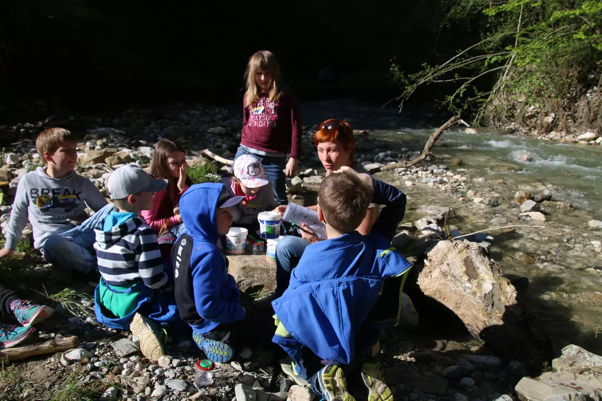 Gruppe sitzt am Bach 