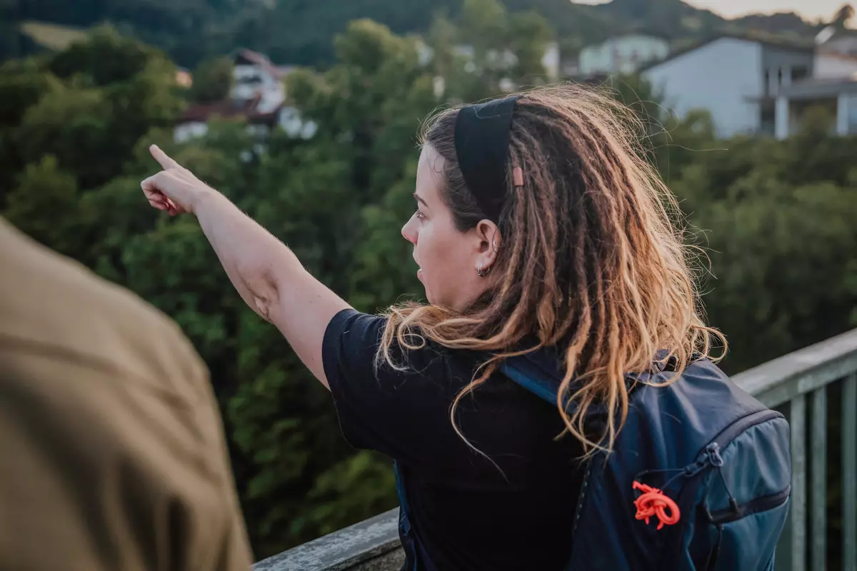 Guide zeigt von einer Brücke aus in die Ferne