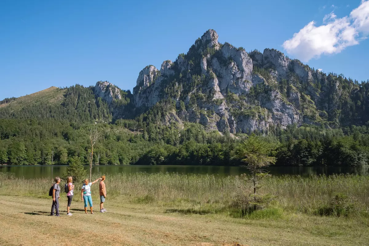 Gruppe von Teilnehmenden neben einem Bergsee