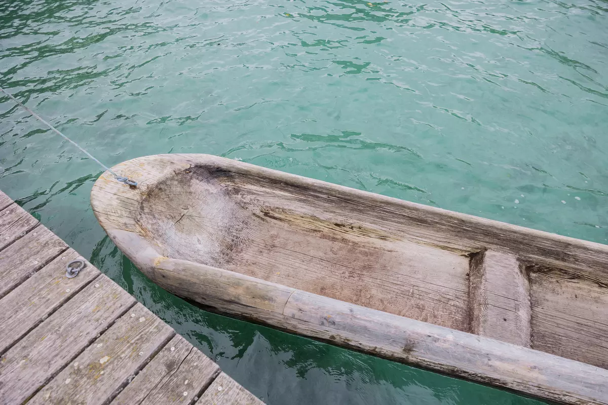 Selbstgebautes Kanu im Wasser neben einem Steg