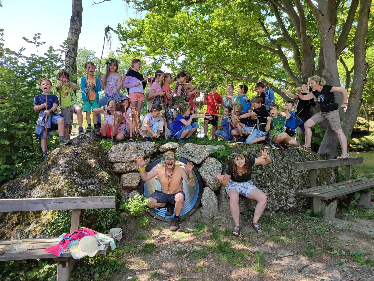 Eine Gruppe von verkleideten Kindern und Guides auf einem Felsen im Schatten eines Baumes